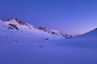 Purple and blue sunrise over snow capped mountains