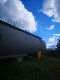 Abandoned train on field against sky