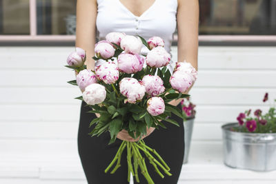 Midsection of woman holding flowers