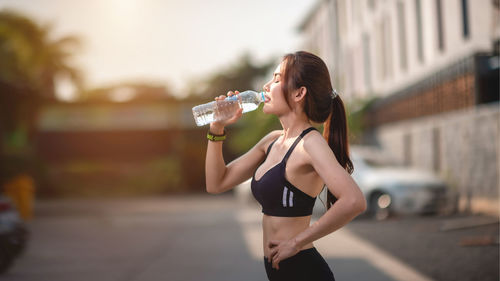 Full length of a beautiful young woman drinking water