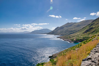 Scenic view of sea and mountains against sky