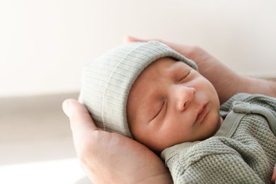 Close-up of newborn cute baby boy in male hands