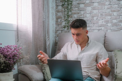 Young woman using laptop while sitting at home