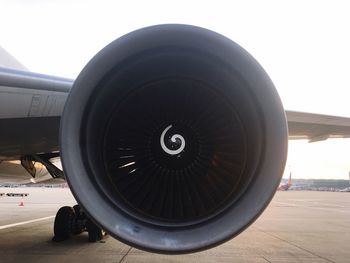 Close-up of airplane on airport runway against sky