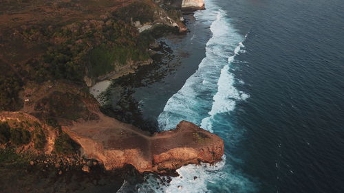 Aerial view of waves crashing on rocky coastline