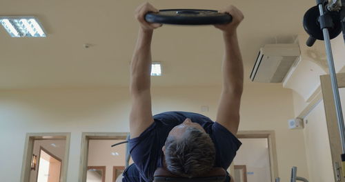 Low angle view of man exercising with weights