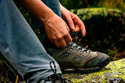 Low section of man tying shoelace outdoors