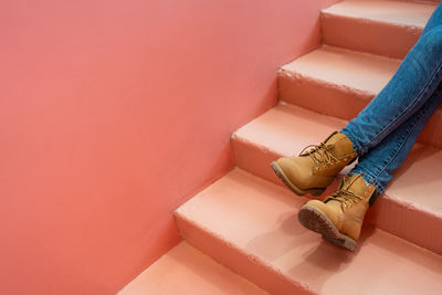 Low section of woman sitting against wall