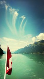 Boats in sea against cloudy sky