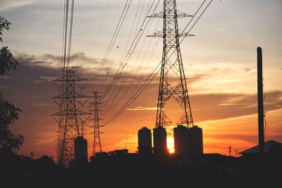 Silhouette electricity pylon against sky during sunset