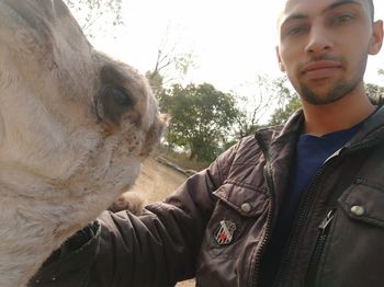 Portrait of young man against sky