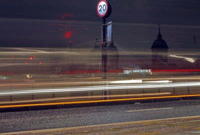 Light trails on road against sky at night