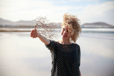 Portrait of young woman standing by river