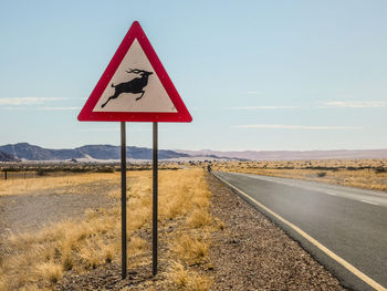 Road sign against sky