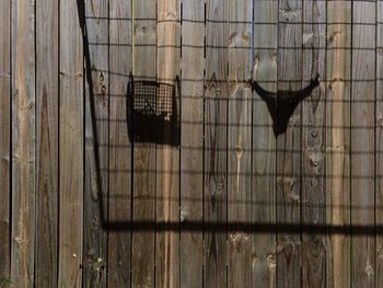 Shadow of woman underwear on wooden fence