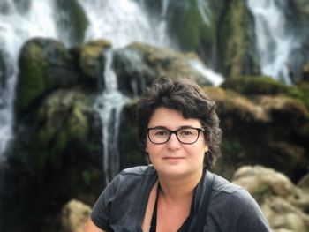 Portrait of smiling woman against waterfall