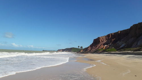 Scenic view of beach against clear blue sky