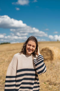 Portrait of smiling young woman standing on field