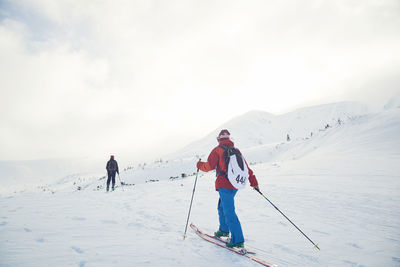 People skiing on snowcapped mountain against sky