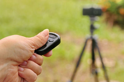 Close-up of hand holding aiming remote control at camera