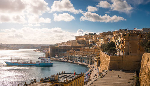 Panoramic view of harbor by sea against sky