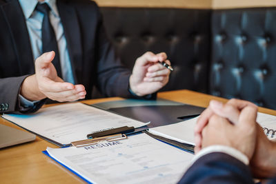 Midsection of couple holding hands on table