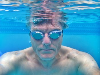 Portrait of shirtless man swimming in pool