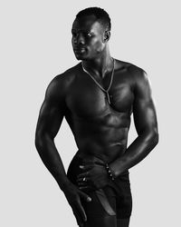 Portrait of shirtless man standing against white background
