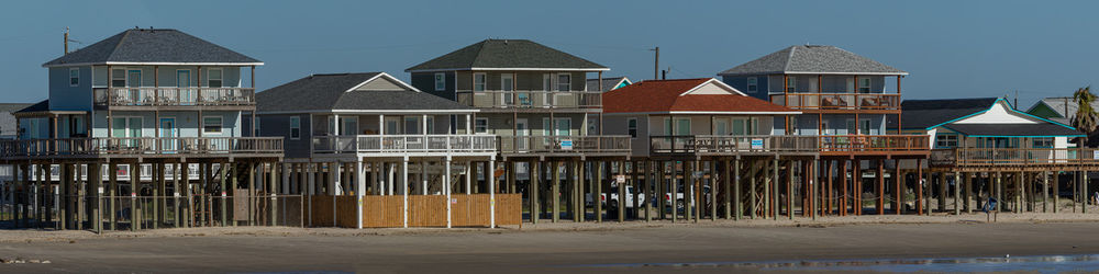 Beachfront homes on stilts by the ocean packed together
