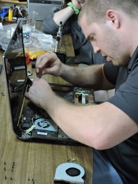 Man repairing laptop on table