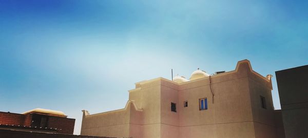 Low angle view of buildings against clear blue sky