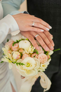 Midsection of bride holding bouquet