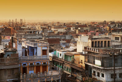 Buildings in city against clear sky during sunset