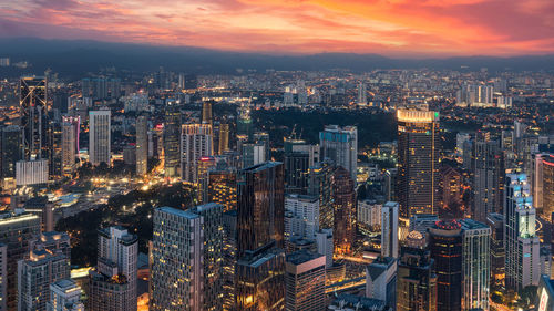 High angle view of city lit up at sunset