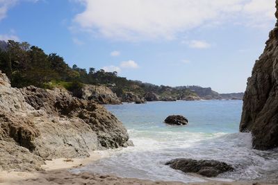 Scenic view of rocky coastline against sky