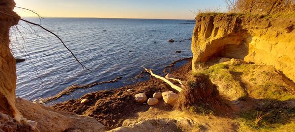 Scenic view of rocks on beach against sky