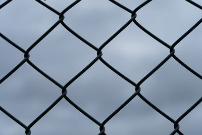 Full frame shot of chainlink fence against sky