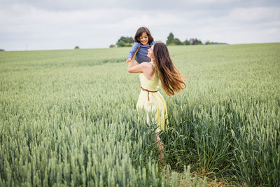 Mother and little handsome baby boy walking in the field