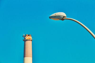 Low angle view of street light against blue sky