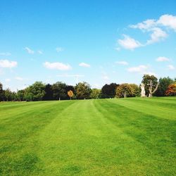 Scenic view of grassy field against cloudy sky