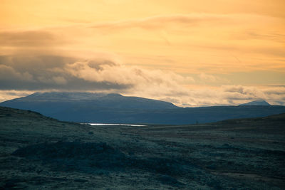 Scenic view of land against sky during sunset