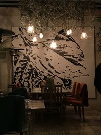 Illuminated pendant lights hanging on table at restaurant