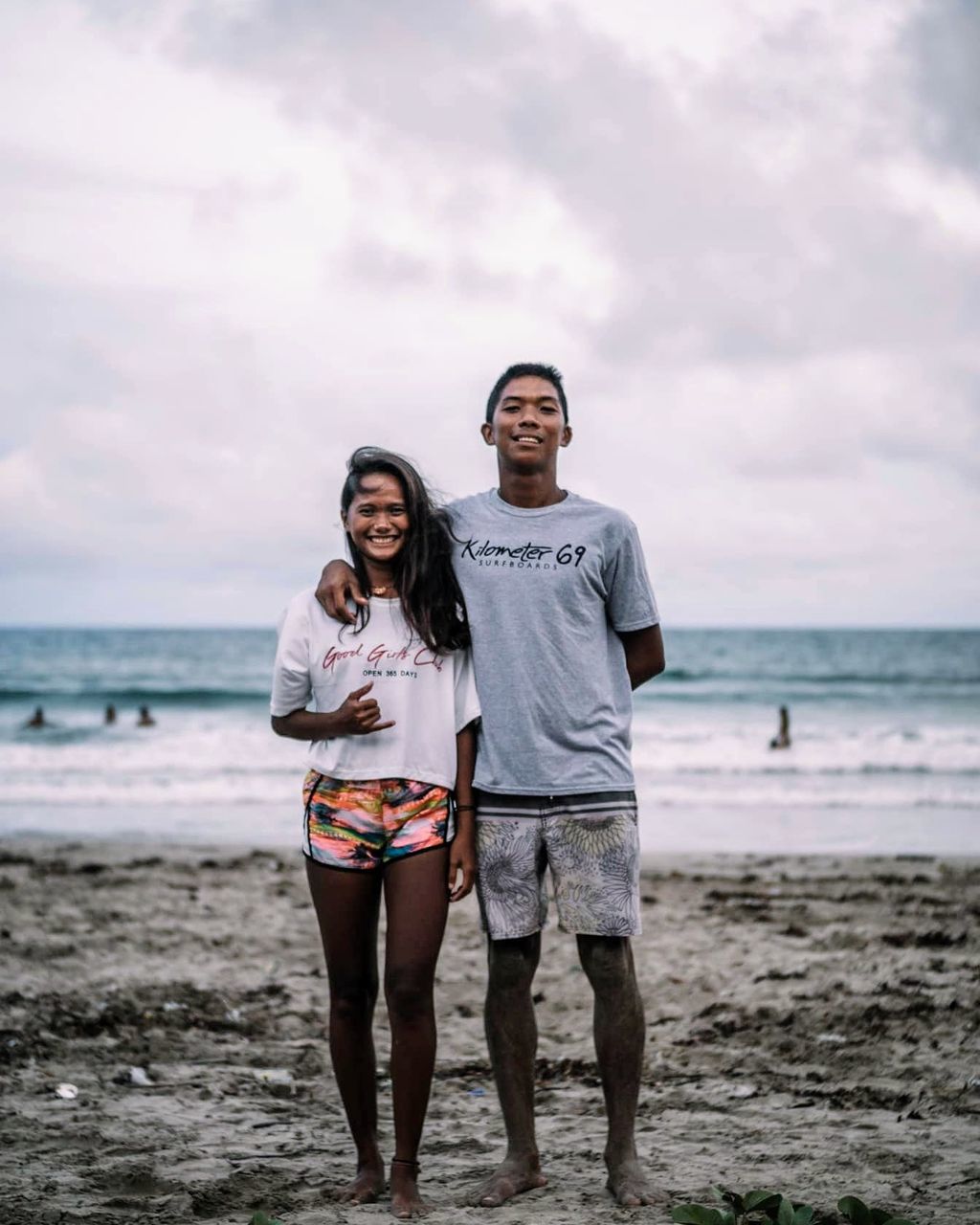 beach, sea, water, two people, land, standing, front view, young adult, leisure activity, togetherness, young women, sky, real people, looking at camera, casual clothing, portrait, bonding, smiling, lifestyles, couple - relationship, horizon over water, positive emotion, outdoors