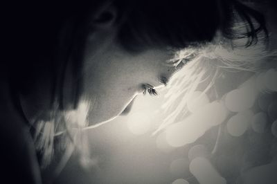 Close-up of teenage girl looking away against illuminated lights at night