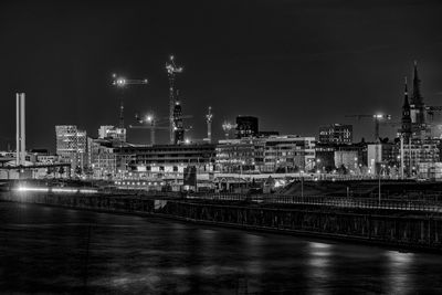 Cityscape by elbe river against sky at night