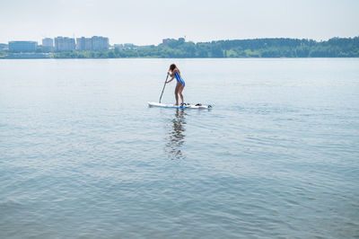 Full length of man standing in sea against sky