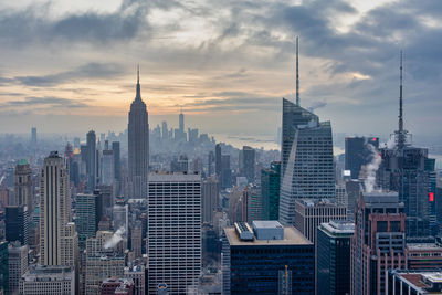 Buildings in city against cloudy sky