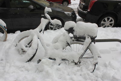 Snow covered bicycle in city