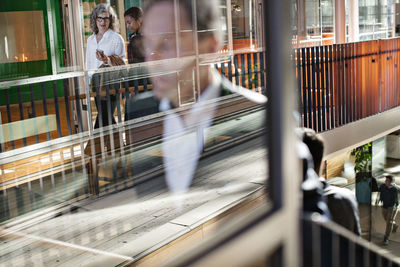 Businesswomen discussing while walking in lobby at modern office