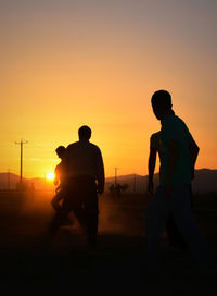 People on field against sky during sunset